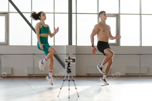 Preview: Attractive hispanic couple working out in gym, making video of exercises. Concept of online blogging