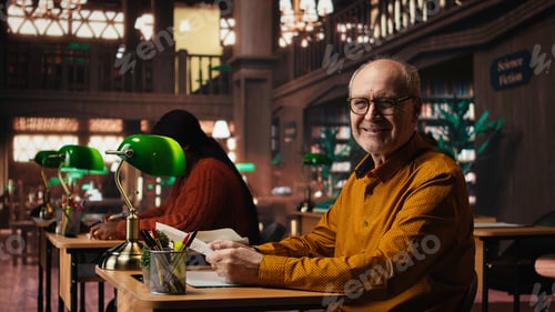 Preview: Senior man at university wearing glasses reading documents with focus