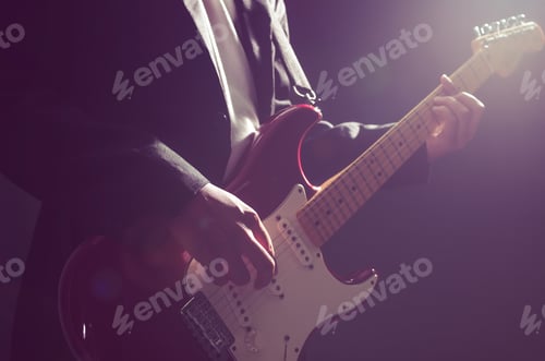 Preview: Musician Playing Electric Guitar in Darkened Room