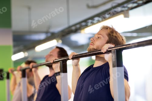 Preview: group of young men doing pull-ups in gym