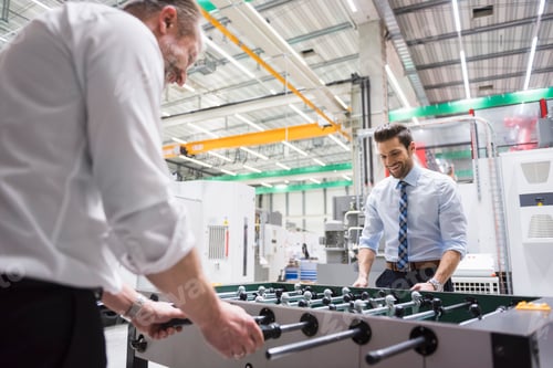 Preview: Two colleagues playing foosball in factory