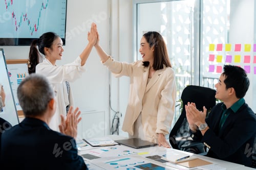 Preview: Corporate colleagues bumping hands, celebrating workplace achievement and teamwork