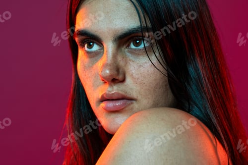 Preview: Young woman showing her freckles and tattoo in beauty portrait