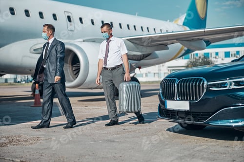 Preview: Chauffer helping boss with luggage to plane