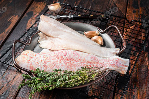 Preview: Raw red perch fillet, redfish fish meat in a steel tray. Wooden background. Top view
