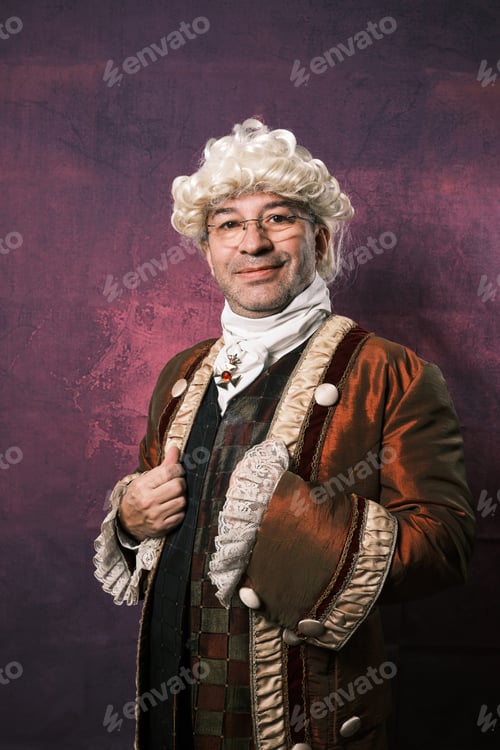 Preview: Man in classical renaissance clothing looking at camera while posing against an isolated background.