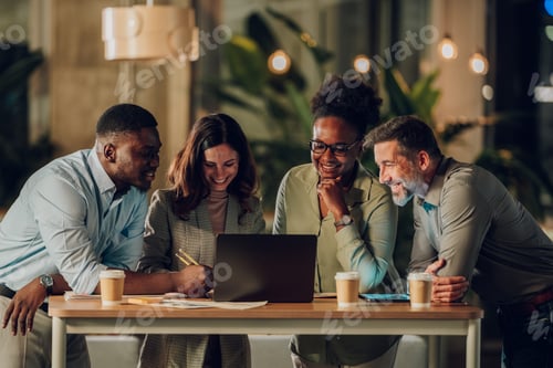 Preview: Diverse business team collaborating using laptop in modern office