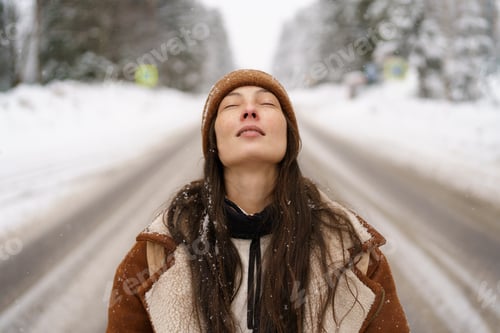 Preview: Happy asian female in sheepskin coat enjoying winter moments, rejoices in snowflakes and closed eyes