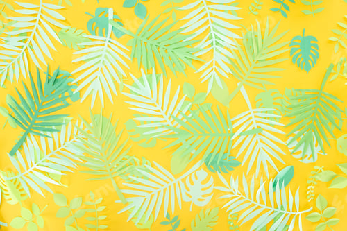 Preview: top view of paper cut green tropical leaves on yellow bright background with copy space