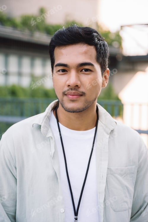 Visualização: Jovem asiático vestindo roupas casuais e cordão posando ao ar livre