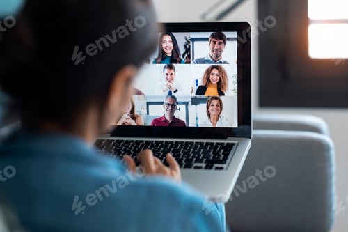 Preview: female employee waving and speaking on video call with her colleague on online briefing