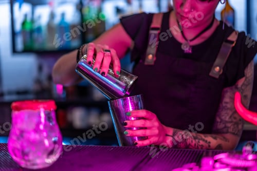 Preview: Waiter mixing ingredient preparing a cocktail in a night bar