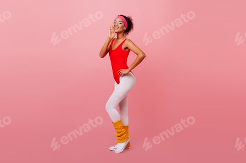 Preview: Full length view of positive african girl wearing aerobics form. Studio shot of sporty female model