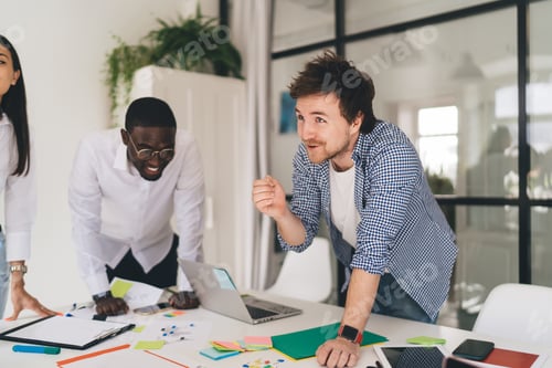 Preview: Ethnic man explaining point of view while diverse colleagues laughing