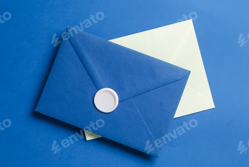 Preview: Beautiful invitation envelope and card on blue background, top view