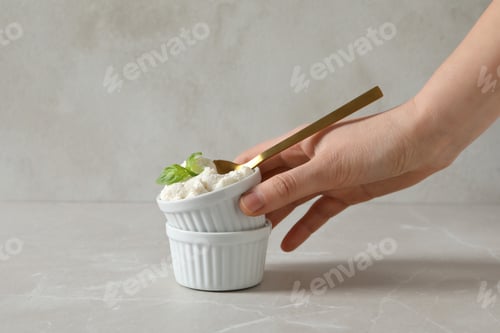 Preview: Ricotta in a bowl with herbs on a light background