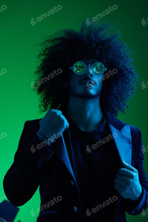 Preview: Fashion portrait of a man with curly hair on a green background with sunglasses, multinational