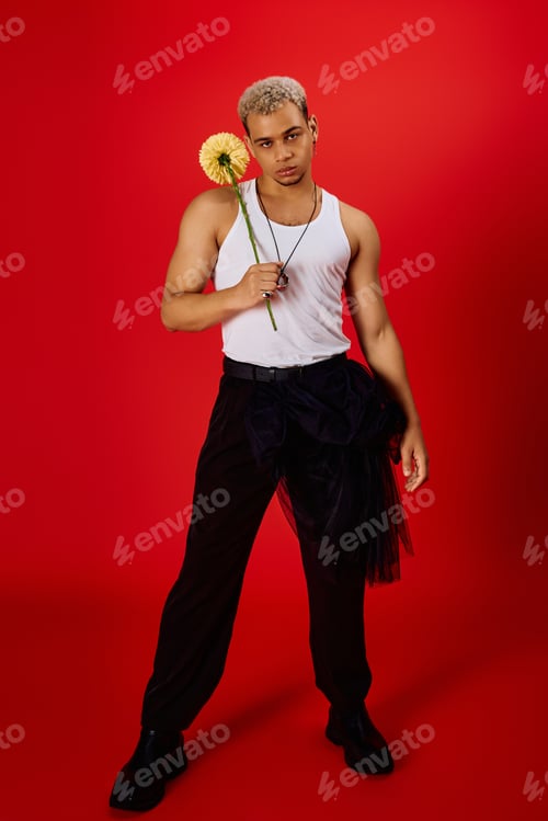 Preview: Bold fashion statement in a vibrant red studio featuring a young man