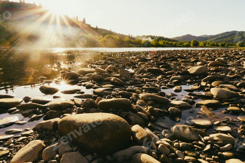 Preview: Pebble stones on the shore close up in the blurry sunset light. Summer nature background