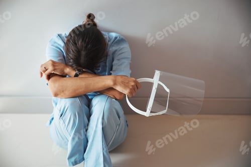 Vista previa: Exhausted depressed doctor sitting in the floor in clinic