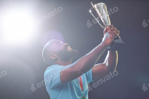 Preview: Black Sportsman Holding Trophy Cup and Cheering