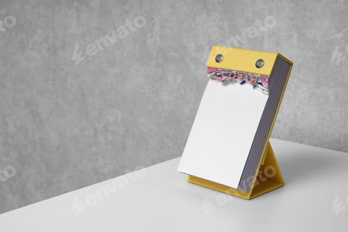 Preview: Blank vertical tear-off calendar with torn pages on white desktop. Mockup. Office life.