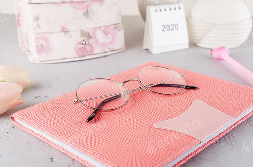 Preview: Feminine styled work place with tulips, eyeglass and notebook.