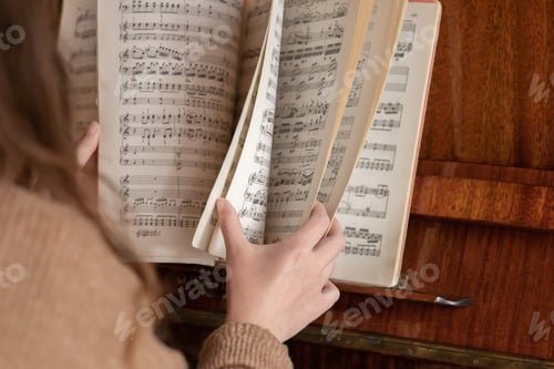 Preview: The woman at the piano leafs through a collection of notes.
