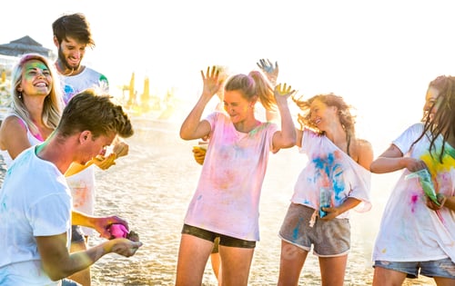 Preview: Happy friends having fun at beach party in holi colors summer festival
