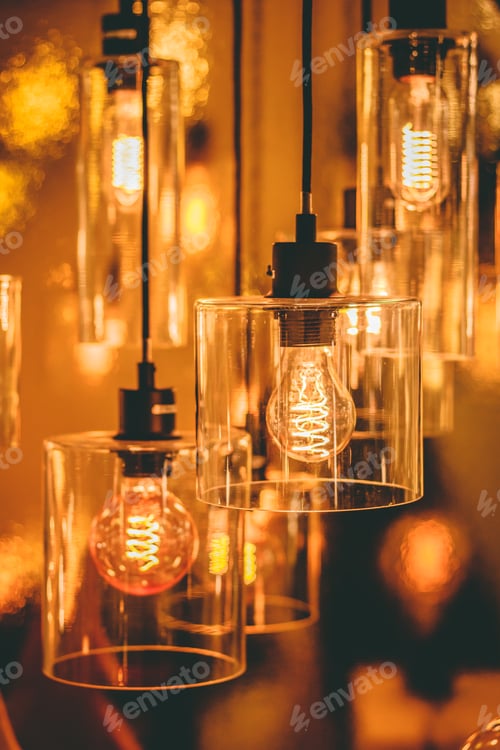 Preview: Close up view on a transparent modern lamp with a retro bulb inside it.