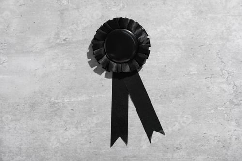 Preview: One black award ribbon on light grey table, top view