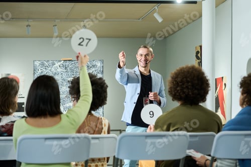 Preview: Pointing at one of female auctioneers
