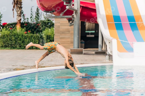Preview: Child jumping and dives in swimming pool at sunny day. Kid boy refreshing and playing at heat