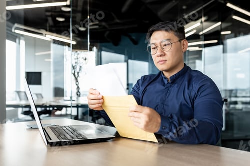 Preview: Serious and focused businessman reading received letter, asian man thinking about mail message