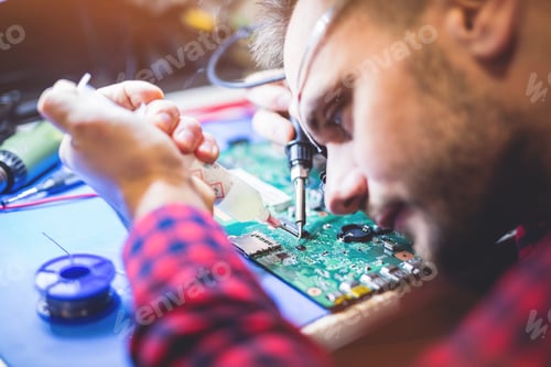 Preview: Man soldering motherboard at workplace