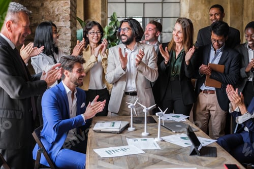 Preview: Group of business people gathered in the office applauding the company's performance improvements