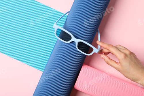 Preview: Blue sunglasses and female hand on blue and pink background