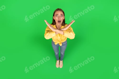 Preview: Emotional Lady Gesturing Stop Crossing Hands Posing Over Green Background