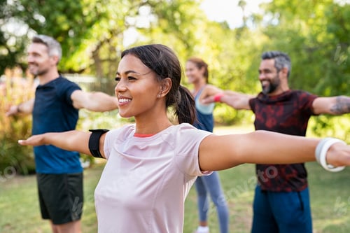 Preview: Mixed race woman exercising in park with mature friends