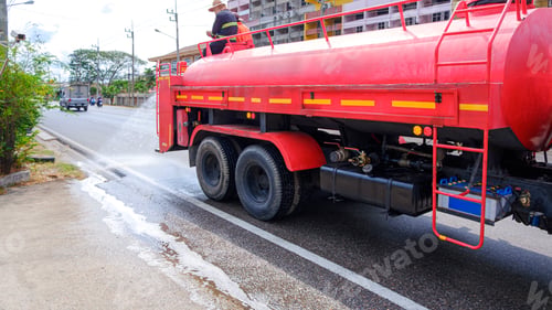 Preview: Worker on fire truck spraying water on the road for reduce PM 2.5 dust levels problem in Thailand