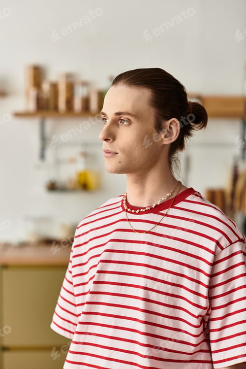 Preview: Young handsome man with a feminine touch stands in a cozy, minimalist space
