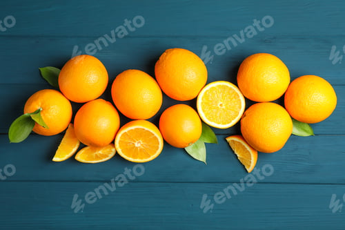 Preview: Flat lay composition with ripe oranges and leaves on wooden background. Top view, space for text
