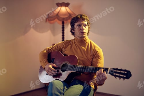 Preview: Male Musician Playing Acoustic Guitar On The Amplifier In Retro Vintage Room.