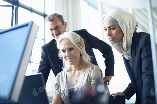 Preview: Business team looking at personal computer at office desk