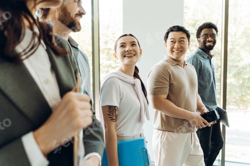 Preview: Diverse business team walking and smiling together in office hallway