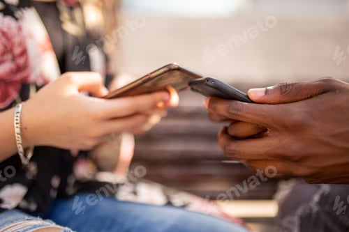 Preview: young multiracial hands holding mobile phones