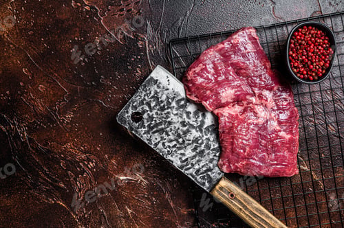 Preview: Raw skirt beef steak on meat cleaver. Black background. Top view. Copy space