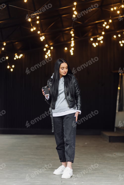 Preview: Stylish Woman with Coffee Poses in Urban Setting