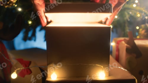 Preview: Hands Opening a Christmas gift freeing all its magic