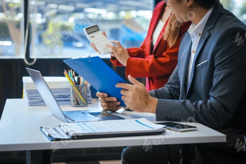 Preview: A businessman and woman sit at a modern office table, smiling discussing a new project or business